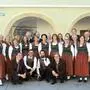 Die Sängerinnen und Sänger des Singkreises Völkermarkt stehen vor dem Alten Rathaus. Sie tragen alle Tracht.