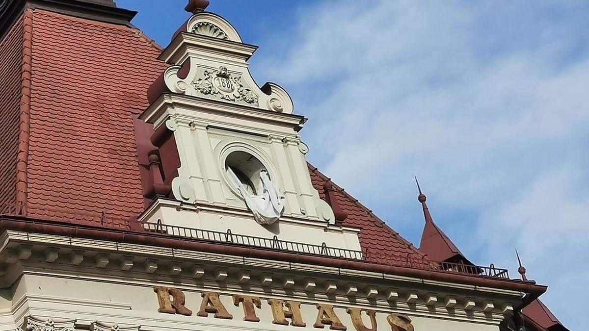 Anstelle der Uhr hängt ein Tuch aus der Giebelöffnung am Rathaus-Dach in Wolfsberg