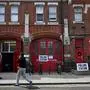 A pedestrian walks past a polling station at The Old Fire Station in Hackney, east London, on July 4, 2024 as Britain holds a general election. Voters will cast ballots from 7:00 am (0600 GMT), with polls predicting that Labour will win its first general election since 2005 -- making its leader Keir Starmer prime minister. (Photo by Paul ELLIS / AFP)