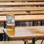 Ein fast leeres Glas Bier steht einsam auf einem Biertisch.