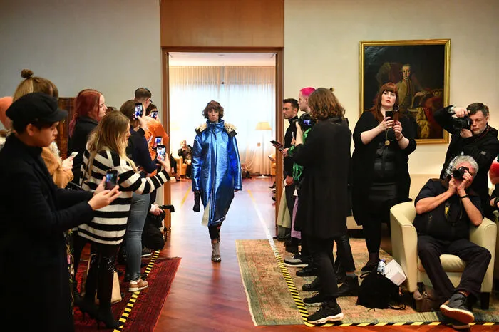 Die Designs der rund 40 in der österreichischen Botschaft in der Berliner Stauffenbergstraße präsentierten Outfits sind wild und laut und hedonistisch, und sie "kleiden Frauen wie Männer und alle dazwischen", so die Intention der Modeschöpferin. Kunstpelz und XXL-Strick sorgten für maximale Silhouetten. Ein Rollikleid und ein Oversized-Pulli fielen durch einen überlangen und viel zu weiten Ärmel rechts auf, links fehlte das gute Stück dafür ganz - wie im Gerangel der letzten Demo zurückgelassen.