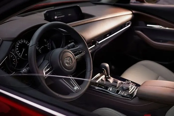 Im Innenraum sind Cockpit und Bedienelemente möglichst ablenkungsfrei angeordnet. Das Infotainment zeigt sich weiterentwickelt, Apple CarPlay und Android Auto inklusive.