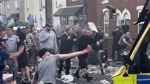 An unruly crowd clash with police, Tuesday, July 30, 2024, in Southport, northwest England, near where three girls were stabbed to death in a dance class the day before. The violence erupted shortly after a peaceful vigil was attended by hundreds in the center of Southport to mourn the 13 victims of the stabbings, including seven still in critical condition.  (Richard McCarthy/PA via AP)