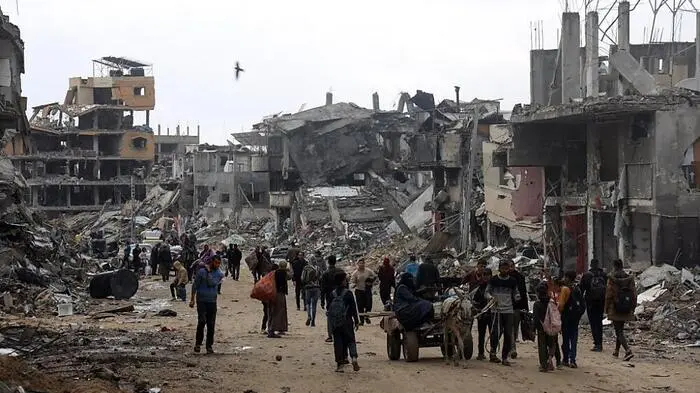 Palästinenser transportieren einige persönliche Gegenstände, nachdem sie kurz nach Khan Yunis im südlichen Gazastreifen zurückgekehrt sind.