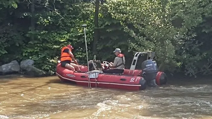 Zwei Experten vermessen die Sohle der Mur