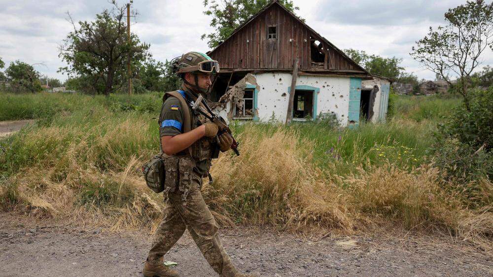Ein ukrainischer Soldat spaziert durch ein rückerobertes Gebiet.