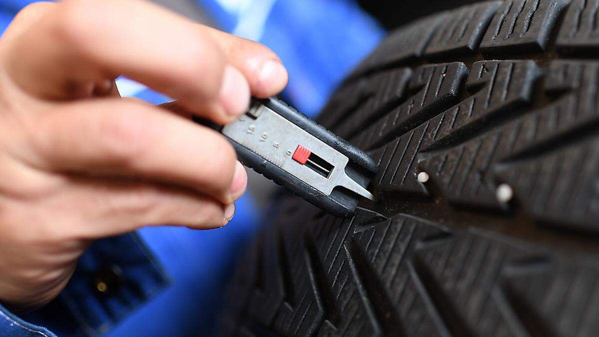Ein Techniker überprüft die Profiltiefe der Reifen