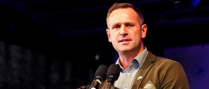 Armin Sippel im Wahlkampf 2021 auf der Bühne, zwei Mikrofone vor ihm am Pult