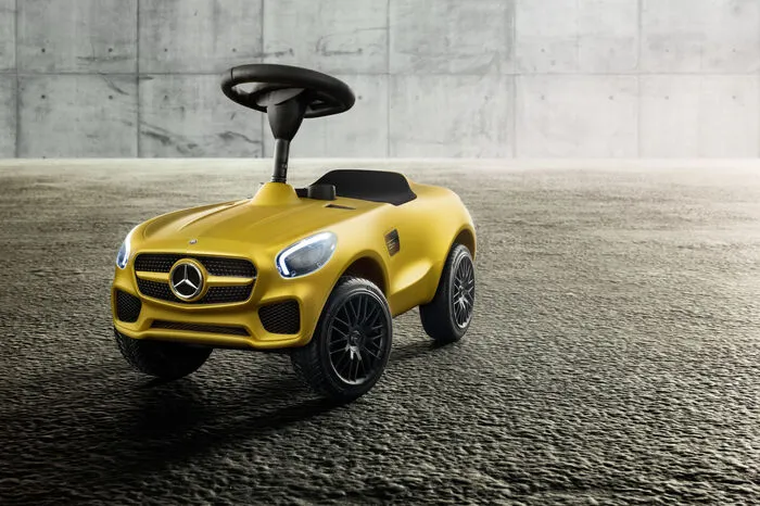 Das Tretauto der fünften Generation steht auf originalgetreuen Nachbildungen der AMG-Schmiederäder im Kreuzspeichen-Design, auch das Lenkrad orientiert sich am Vorbild im Maßstab 1:1, genauso wie die zweitubigen Instrumente und die detaillierten Front- und Heckscheinwerfer in Klarglas.