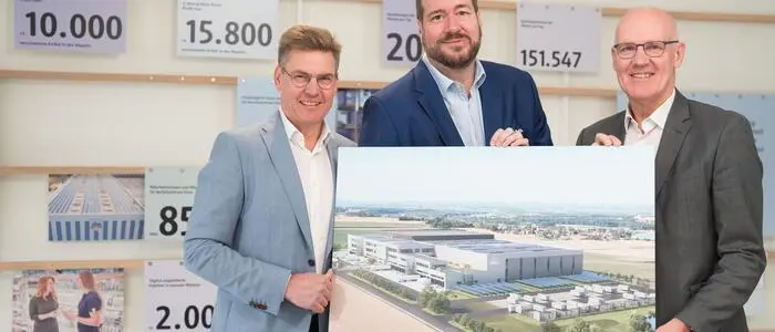 Harald Bauer, Vorsitzender der dm Geschäftsführung (Mitte), Thomas Köck (li.) und Martin Engelmann (re.) freuen sich über die erreichten Meilensteine beim Bau des neuen dm Verteilzentrums in Kronstorf