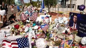 People gather at a makeshift memorial for political activist and Turning Point USA Founder Charlie Kirk outside of the Turning Point USA headquarters in Phoenix, Arizona, on September 14, 2025. The widow of prominent right-wing activist Charlie Kirk pledged on September 12 to carry on her husband's work, after US authorities announced his alleged assassin had finally been captured. The 31-year-old Kirk was hit by a single bullet while addressing a large crowd at Utah Valley University in the town of Orem on September 10. (Photo by CHARLY TRIBALLEAU / AFP)