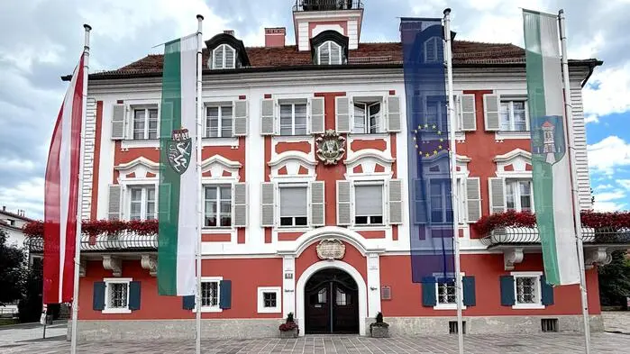 Die kunstvoll gestaltete Fassade des Deutschlandsberger Rathauses mit Stadtwappen und historischem Sinnspruch über dem Eingang