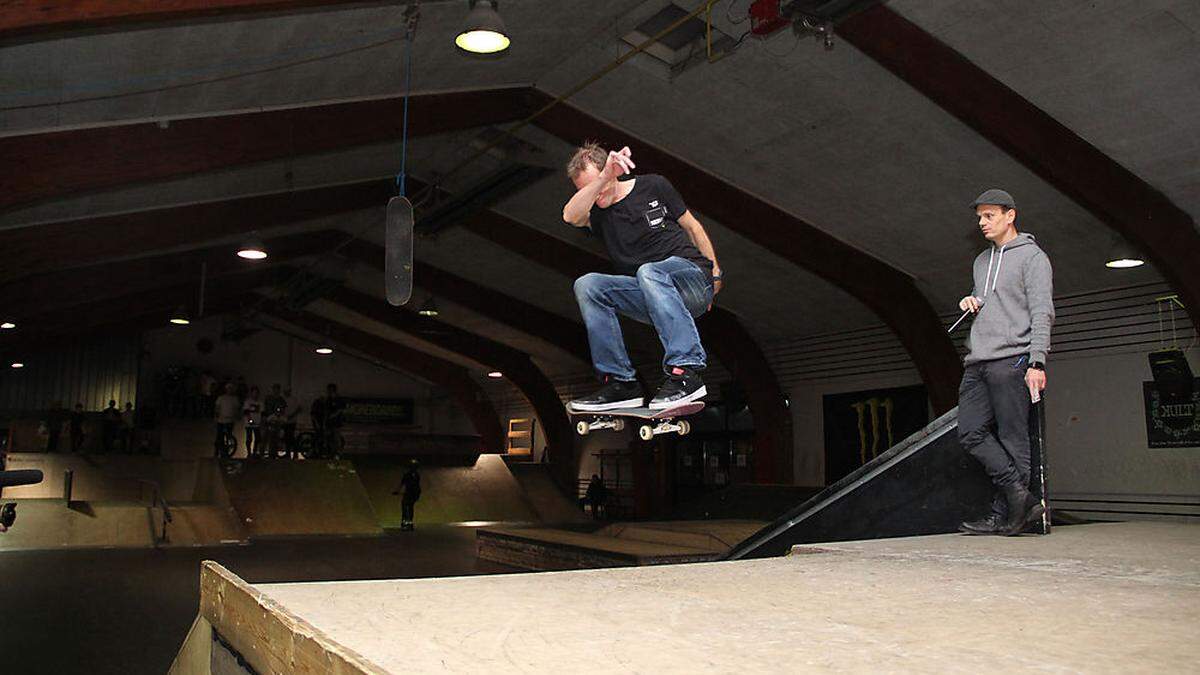 Skateboard-Fahrer vollführen auf den Rampen der Trendsporthalle beeindruckende Stunts.