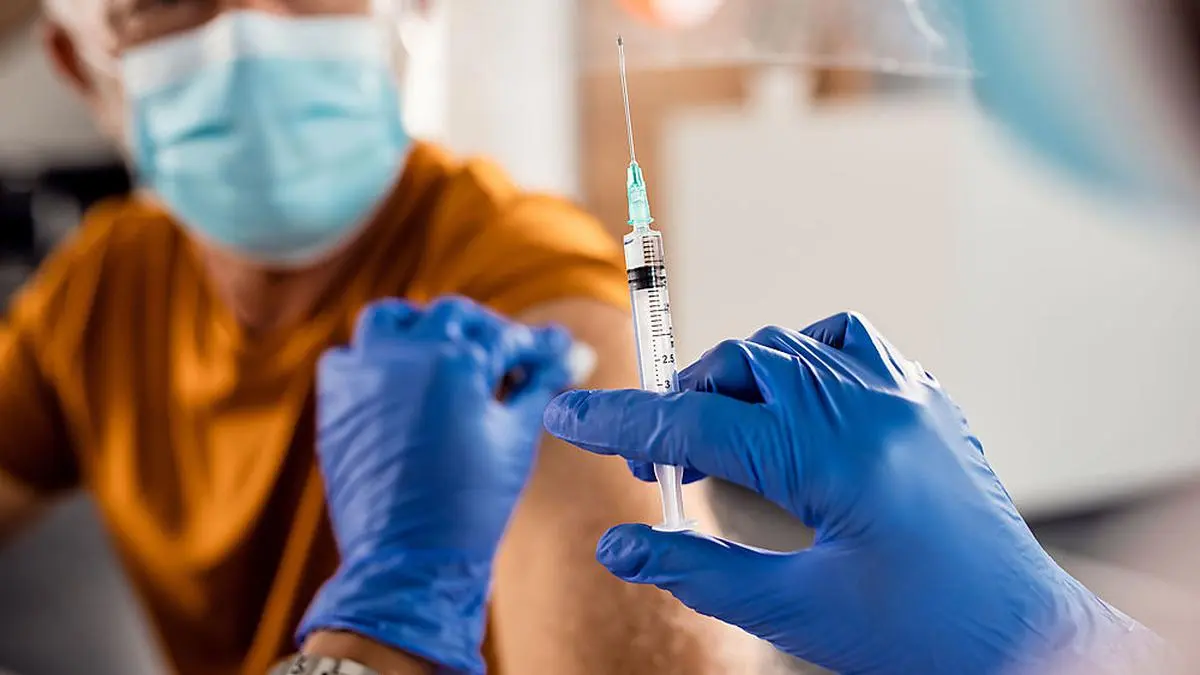 Close-up of senior patient receiving a vaccine due to coronavirus pandemic.
