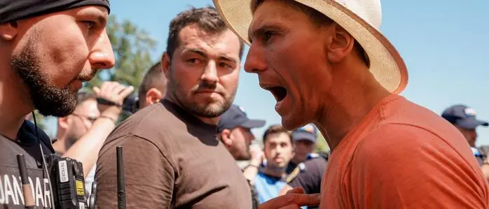 Ein Demonstrant schreit einen ihm gegenüberstehenden Polizisten an