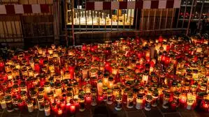 Viele brennende Kerzen stehen auf einem Platz in einer Stadt