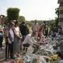 People pay tribute to late French actor Alain Delon, at the entrance gate of Delon's property, in Douchy, central France, Saturday, Aug. 24, 2024. Delon who died at age 88 will be buried on Saturday at his family home in Douchy. (AP Photo/Thibault Camus)
