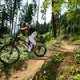 Eine Bikerin und ein Biker fahren auf einem Trail im Bikepark Lienz