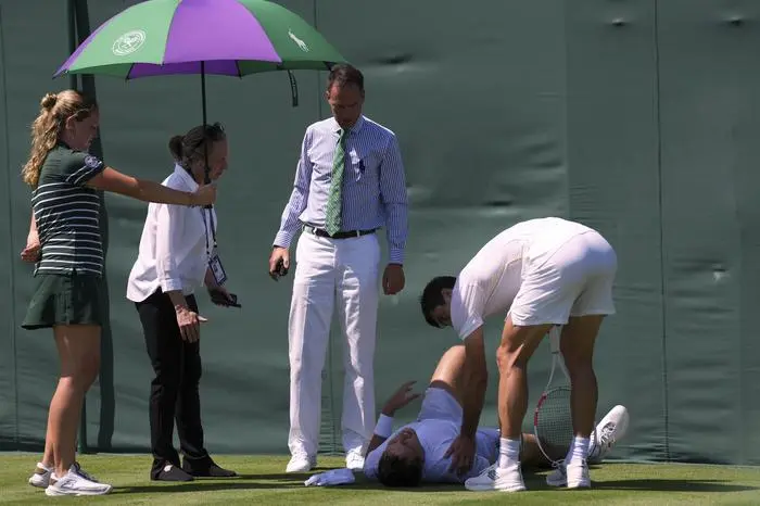 Hamad Medjedovic of Serbia lies injured on the court after he ran into a board during his first round men's singles match against Sebastian Ofner of Austria at the Wimbledon Tennis Championships in London, Tuesday, July 1, 2025.(AP Photo/Dave Shopland)