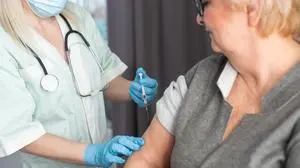 Senior vaccination concept. Elderly getting immune vaccine at arm for flu shot, pneumonia, and shingles in hospital by nurse. Doctor giving an injection to older people patient in clinic.