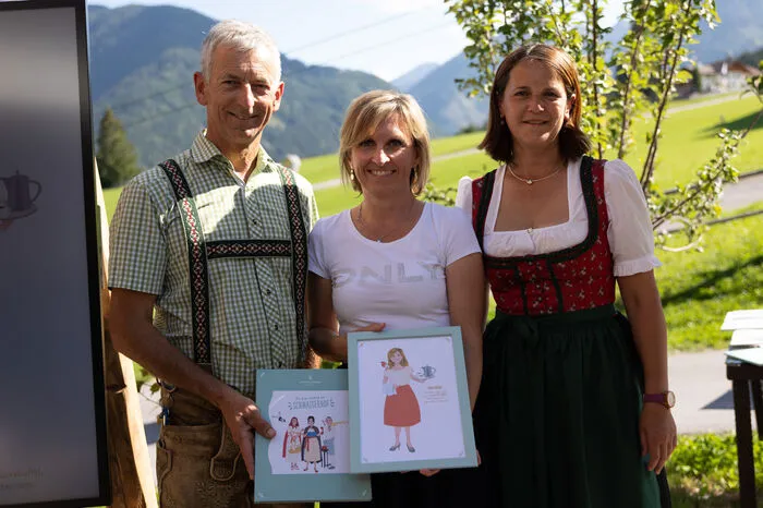 Hotelinhaber Annemarie und Gottlieb Stocker bei der Übergabe der Illustrationen an ihre Mitarbeiter