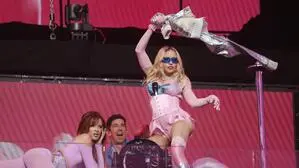 Madonna auf der Bühne in pinkem Outfit mit blauer Sonnenbrille