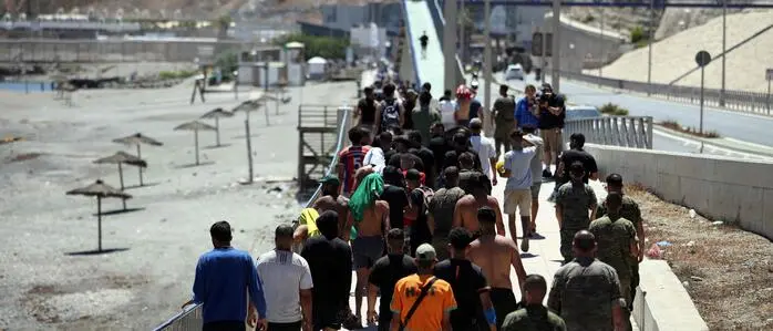 Eine Gruppe von Migranten in Ceuta macht sich auf den Weg zurück nach Marokko.
