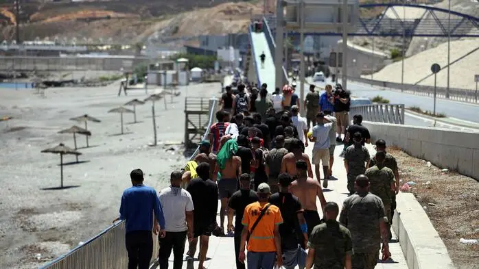 Eine Gruppe von Migranten in Ceuta macht sich auf den Weg zurück nach Marokko.