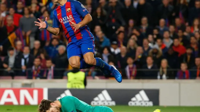 Luiz Suarez hechtet in vollem Einsatz über Goalie Kevin Trapp von Paris Saint-Germain.