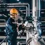 Portrait of young Caucasian man dressed in work wear using tablet while standing in heating plant.