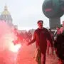 A protester burns a flare during a demonstration in Paris, on October 18, 2022 after the CGT and FO trade unions called for a nationwide strike for higher salaries, and against the government's requisitioning of fuel refineries to force some strikers back into opening fuel depots. - Unions in other industries and the public sector have also announced action to protest against the twin impact of soaring energy prices and overall inflation on the cost of living. (Photo by Bertrand GUAY / AFP)