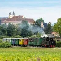 Der Flascherlzug auf seiner Fahrt, im Hintergrund Schloss Stainz