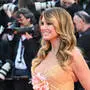 Heidi Klum in einer goldenen Robe mit rosa Blume am Dekolleté