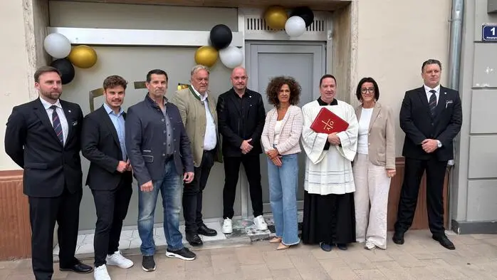Ein Gruppenfoto auf dem Männer und Frauen verschiedenen Alters zu sehen sind: