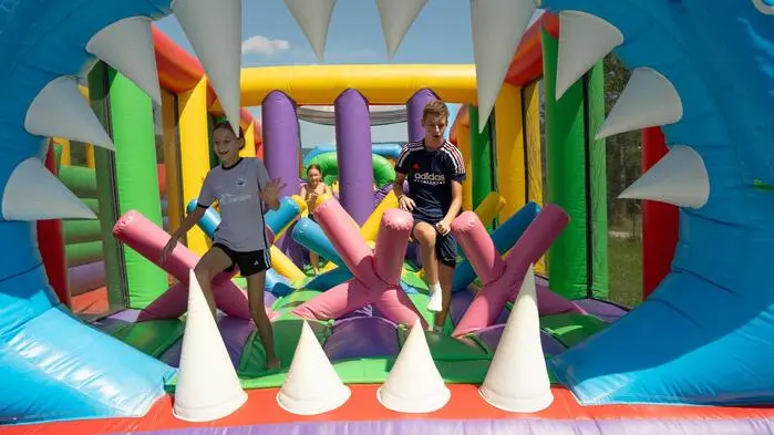 Kinder springen auf einer riesengroßen Hüpfburg
