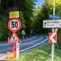 Blick auf mehrere Verkehrsschilder neben einer Straße, die auf Arbeiten hinweisen