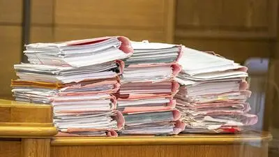 Die Aktenberge sind der Rechtspflegerin über den Kopf gewachsen