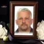 Ein Bilderrahmen mit dem Foto eines Verstorbenen. Links und rechts liegen weiße Blumen | Markus Eder verstarb am 13. Dezember plötzlich und unerwartet. Die Verabschiedung findet am 20. Dezember statt