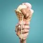 Sujetfoto: Hand hält Tüte mit schmelzendem Eis