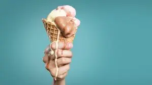 Sujetfoto: Hand hält Tüte mit schmelzendem Eis