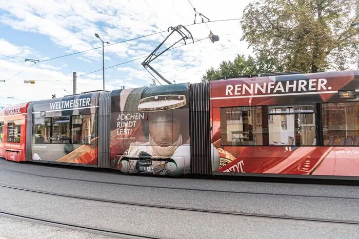 Die Tram ziert ein großes historisches Foto von Rindt und die Wörter "Weltmeister, Weltenbürger, Popstar"