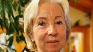 Eine Dame mit einer schulterlangen weißen Haaren und einer Perlenkette