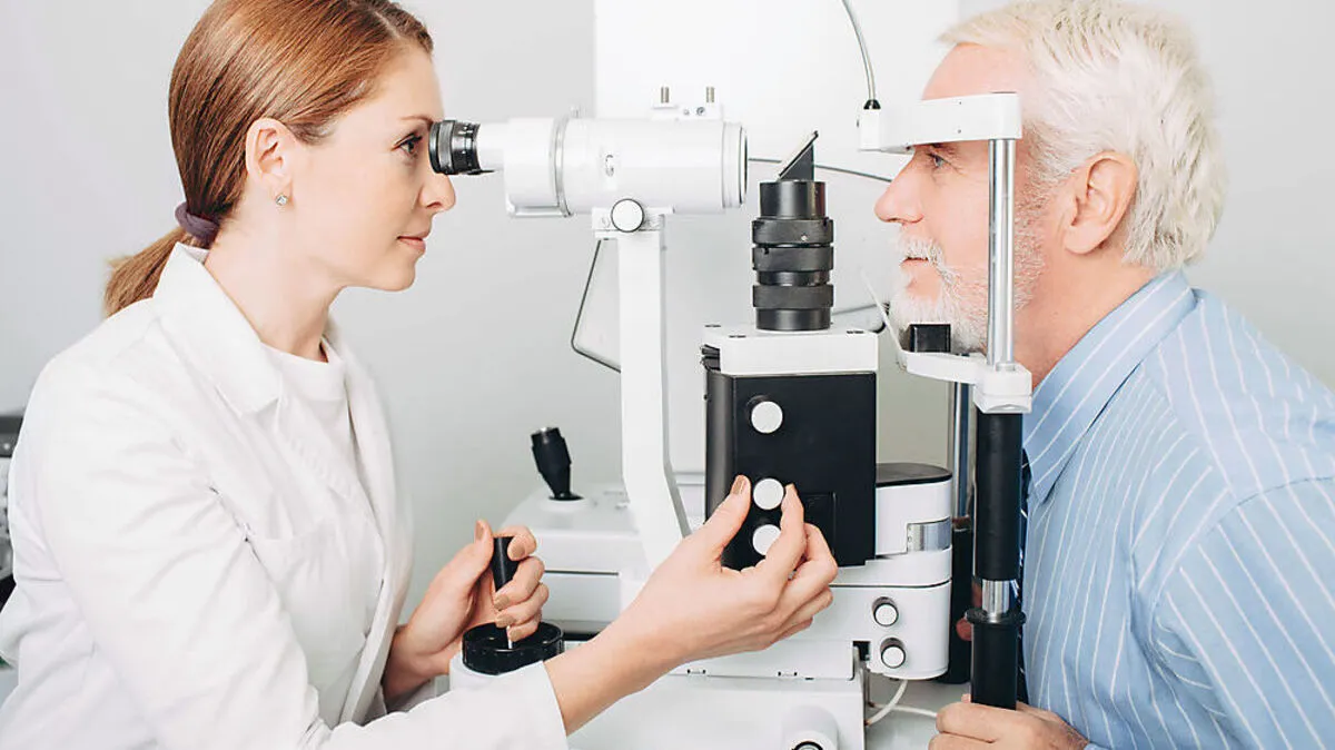 Senior man getting eye exam at clinic, close-up