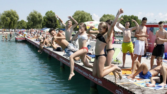 Kinder springen vom Steg in den See.