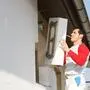Ein Arbeiter bringt eine Dämmplatte an einer Hauswand an (Sujetfoto)