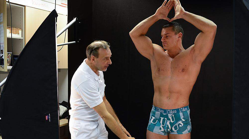 Testimonial Bodybuildingweltmeister Klaus Drescher steht beim 3D-Fotoshooting auf dem nahezu unsichtbaren Drehteller vor der schwarzen Stoffwand (rechts)