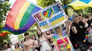 Participant of the 'Regenbogenparade' (Pride Parade) holds a sign reading âfree love, free UkraineÒ at Ringstrasse in Vienna, Austria, on June 17, 2023. (Photo by Alex HALADA / AFP)