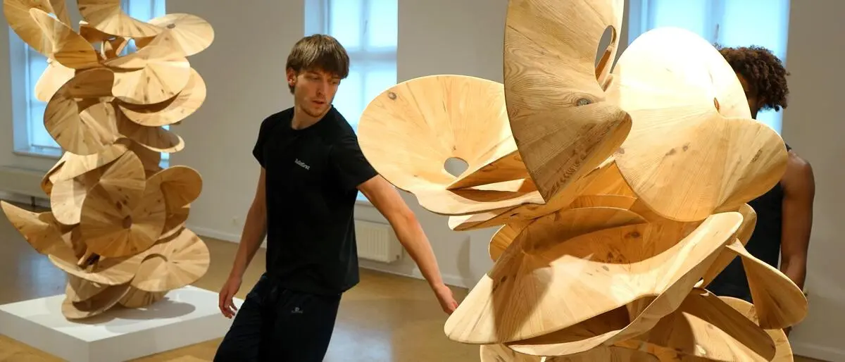Tänzer Hannes Lüttringhaus neben einer Skulptur von Koloman Wagner