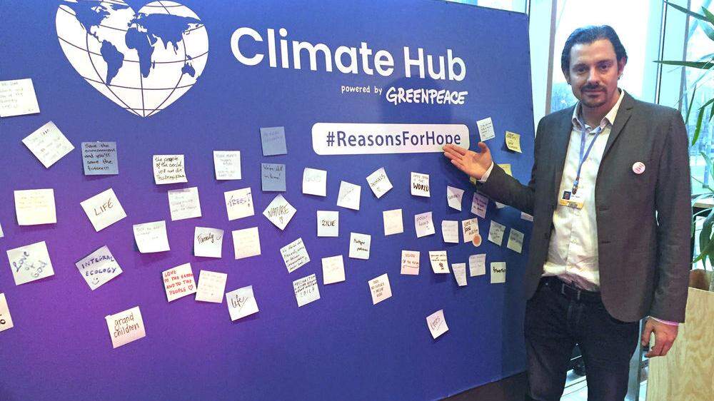 Adam Pawloff im Climate Hub von Greenpeace neben dem Tagungsgelände des Klimagipfels. Auf der Wand verewigte sich zu Wochenbeginn auch  Bundespräsident Van der Bellen