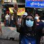 Menschen in Yangon zeigen den Dreifingergruß der Rebellen aus der Science-Fiction-Filmreihe „Die Tribute von Panem“. 